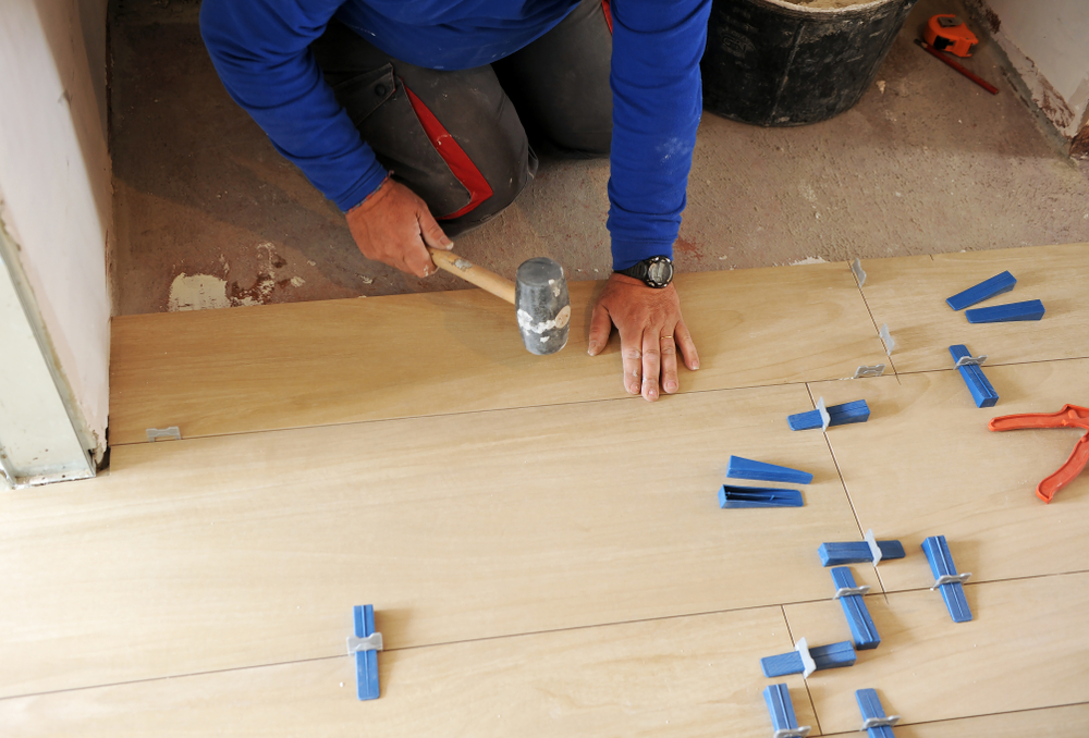 Construction,Worker,Using,The,Rubber,Hammer,To,Place,A,New